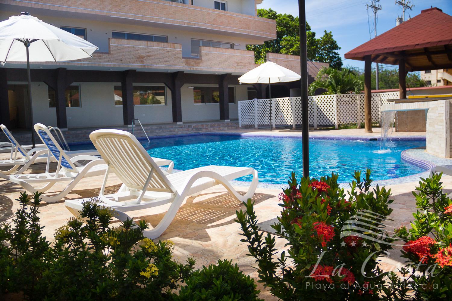 Piscina con tumbonas y cascada